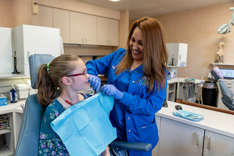 Assistant preparing patient for visit at Lufkin Kids Dentistry