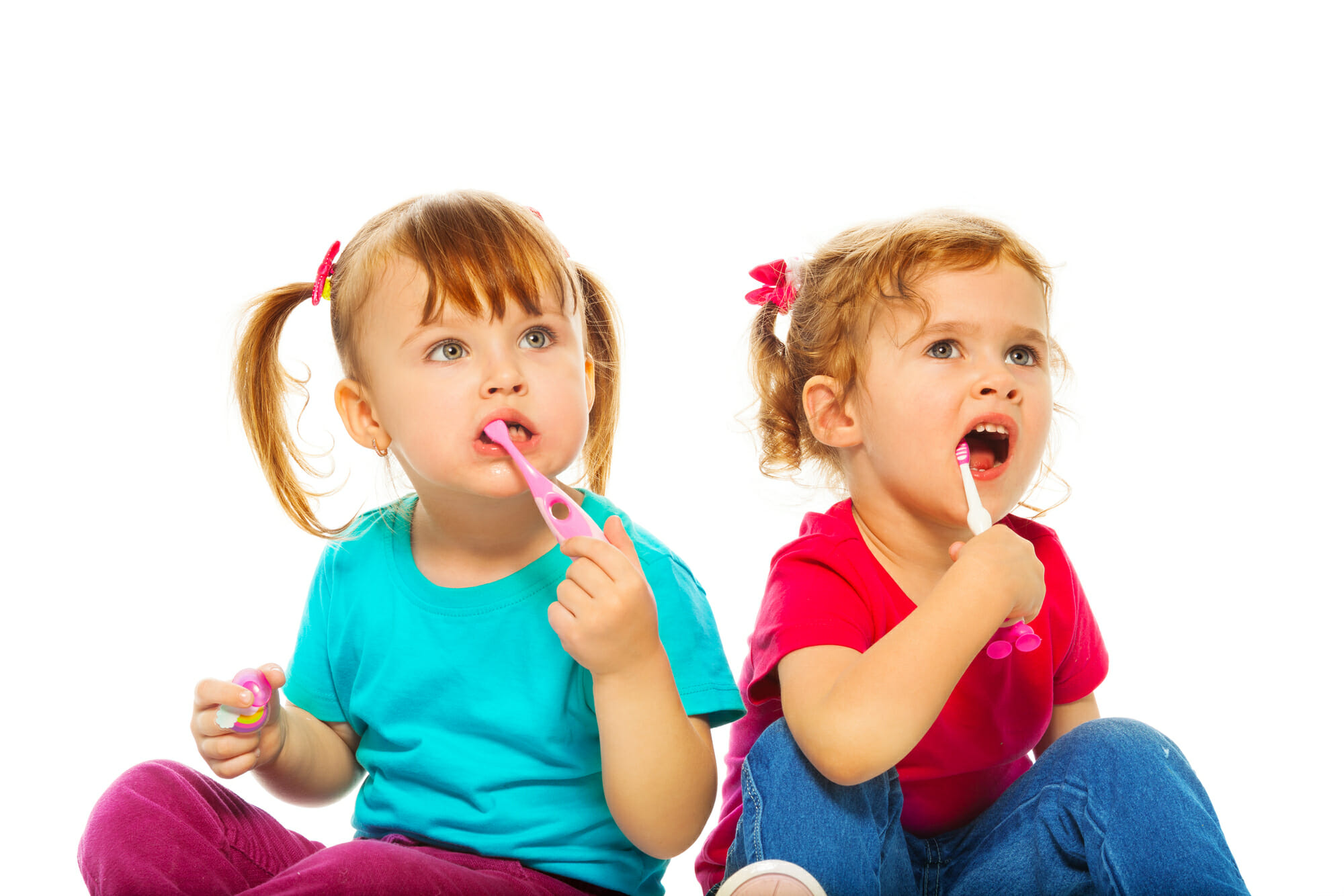 Lufkin Kids Dentistry 2 young pediatric girls content while sitting and using a tooth brush each one is holding 