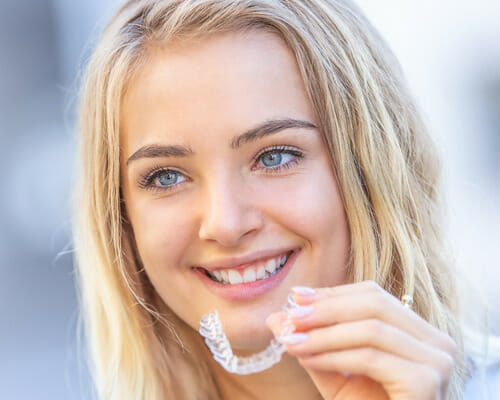 smiling teenager with bright blue eyes smiling after visiting a dentistry in Lufkin to get her new Invisalign